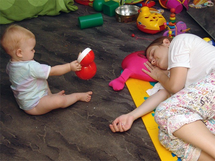 Baby spielt Mutter schläft
